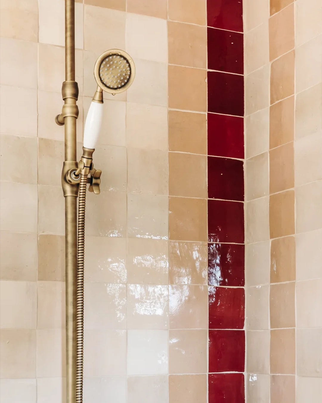 Shower walls in beige, pink and red featuring frame pattern 